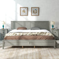 Gray king platform bed with paneled headboard, slatted base, and fitted bedding