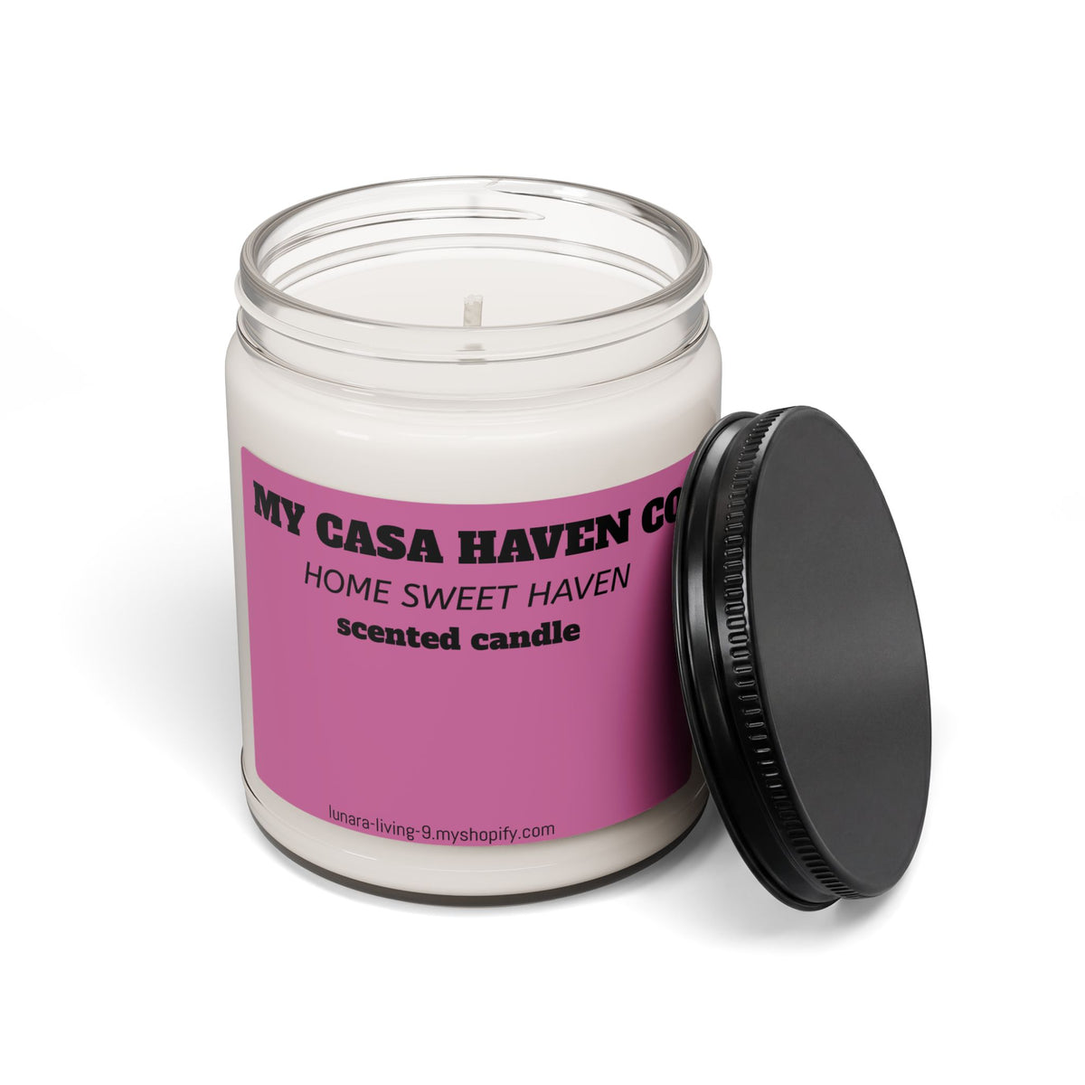 Scented soy candle in clear glass jar with black lid open, purple label