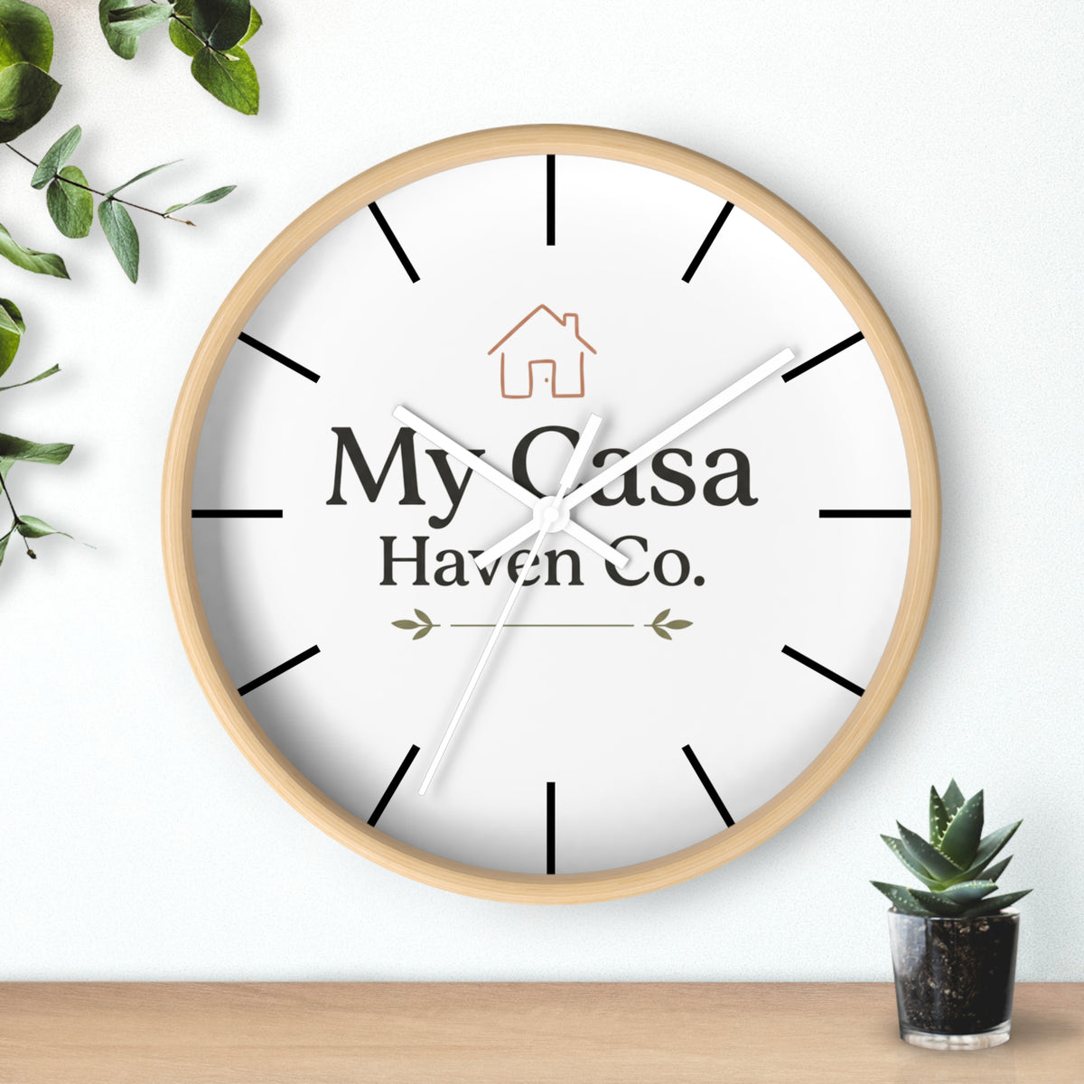 Light wood rim wall clock with white dial, white hands and black hour marks.