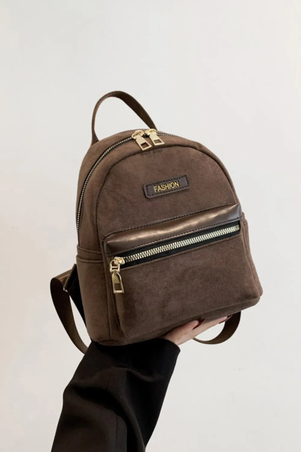 Suede brown mini backpack with top handle, adjustable strap, and front zipper pocket