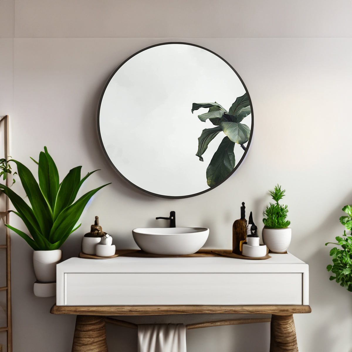 Round bathroom mirror with black metal frame and reflective glass, plant reflections visible
