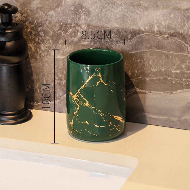 Green ceramic tumbler with golden marble veining, glossy finish, round rim