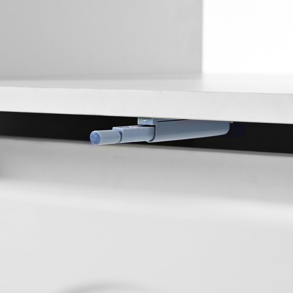 Close-up of blue-tinted caster and under-drawer support bar on a white table
