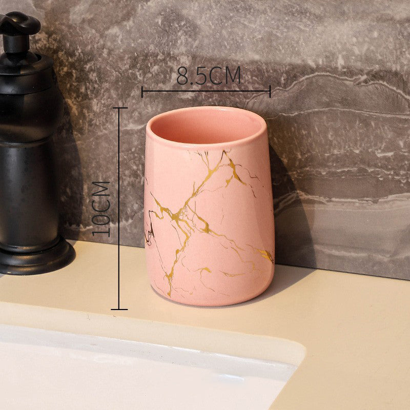 Pink ceramic tumbler with golden marble veining, glossy finish, round rim
