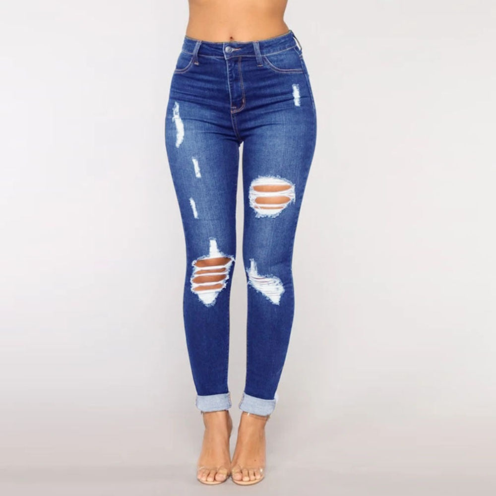 Dark blue women's ripped skinny jeans with thigh and knee distress, frayed edges