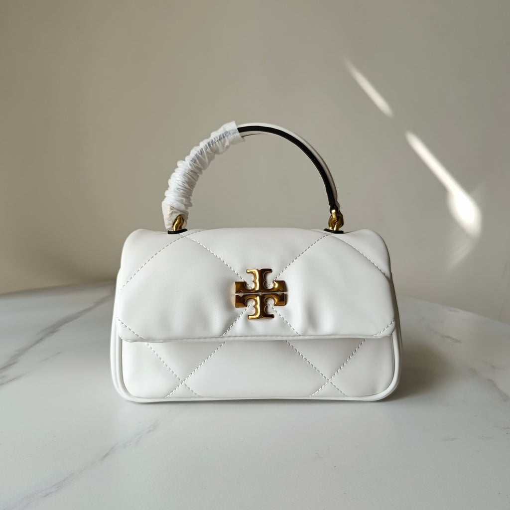 White quilted crossbody bag with gold logo clasp, curved top handle and shoulder strap