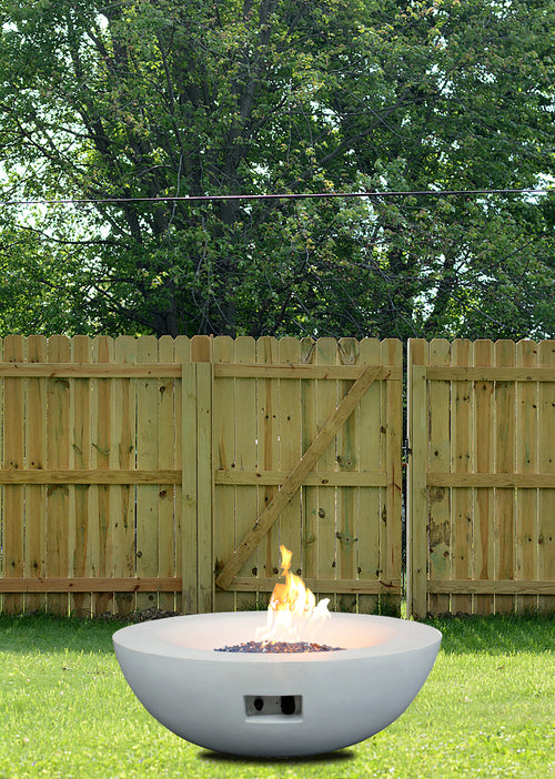 Antique white concrete propane fire pit bowl outdoors with flames rising in center
