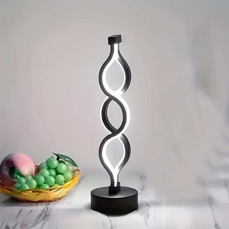 Black bar table lamp with looped silhouette frame and round base, lit white glow