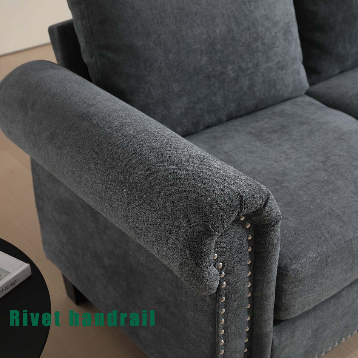 Gray upholstered sofa arm and seat cushion with rounded corner, nailhead trim