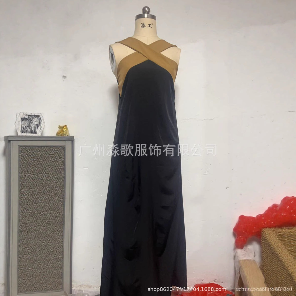 Black sleeveless maxi dress with crisscross back straps on mannequin form